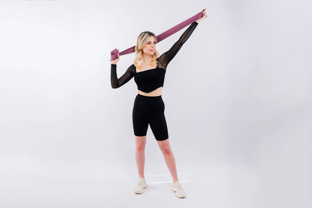 Photo of woman workout with a resistance band. Strength and motivation. - Photo, Image
