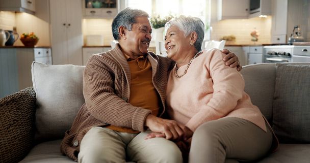 Starší pár, tvář a objetí na gauči, úsměv a sblížení s láskou, podpora a odpočinek v důchodu doma. Starší žena, starý muž a portrét s objetím, spolu a sedí na pohovce v obývacím pokoji. - Fotografie, Obrázek