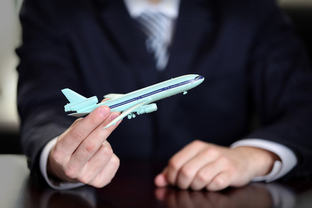 Businessman holding airplane model in hand in office, closeup - Zdjęcie, obraz