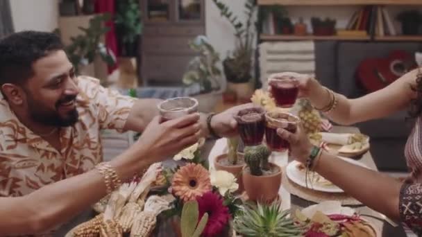 Full zoom out beelden van vier jonge Mexicaanse mannen en vrouwen genieten van feestelijk diner samen tijdens de nationale feestdag, zeggen toast, heffen en klinkende glazen margarita, voortdurende gesprek - Video