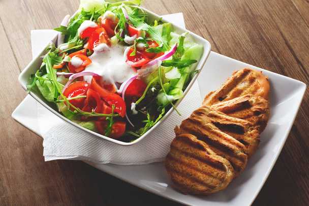 Salada fresca com tomate e molho e pão
 - Foto, Imagem