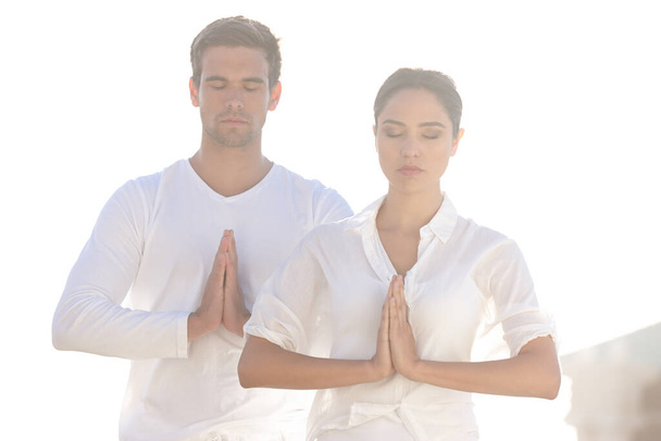 Meditation, prayer pose and couple at yoga retreat with peace, relax and calm mindfulness at outdoor resort. Zen, man and woman together in holistic health, spiritual wellness and namaste with hands. - Φωτογραφία, εικόνα