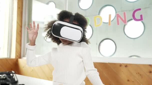 Meta-evrende öğrenmek için VR kulaklık takan yaratıcı kız. Komik çocuk yapay zeka kulaklığı takıp BTMM teknoloji sınıfında sanal dünya programına katılmayı seviyor. Yenilik. Gelecekteki yaşam tarzı. Etkinlik. - Video, Çekim