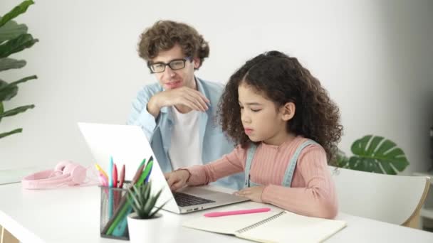 Amerikaanse dochter leren coderen en schrijven engineering prompt terwijl positieve slimme vader samen studeren en wijzen naar laptop scherm om programmeren code of systeem met zorg te tonen. Pedagogie. - Video