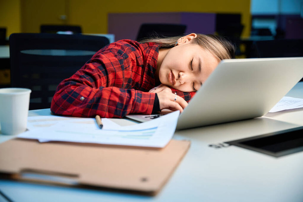 Nuori väsynyt aasialainen IT-johtaja nukkuu työpöydän ääressä coworking toimistossa. Käsitteen moderni freelance tai etätyötä - Valokuva, kuva