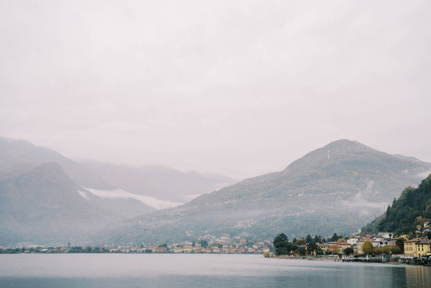 Montagne nebbiose sulla costa del Lago di Como con ville di lusso. Italia. Foto di alta qualità - Foto, immagini