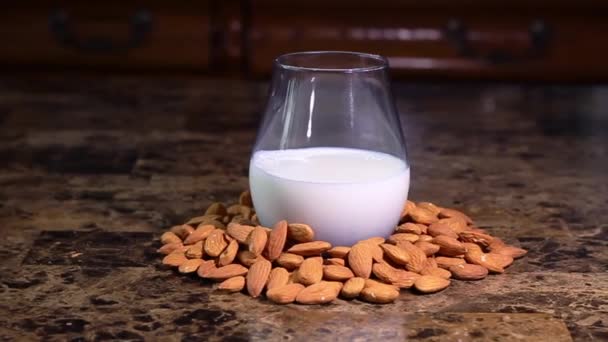 slider αργή κίνηση από γυαλί με γάλα αμυγδάλου που περιβάλλεται από αμύγδαλα - Πλάνα, βίντεο