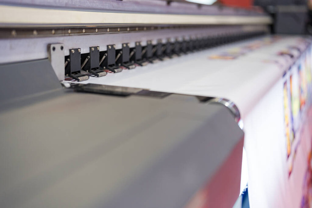 Zbliżenie głowic drukarek wielkoformatowych w akcji, szczegółowy widok nowoczesnych głowic drukarek wielkoformatowych pracujących na białych nośnikach - Zdjęcie, obraz