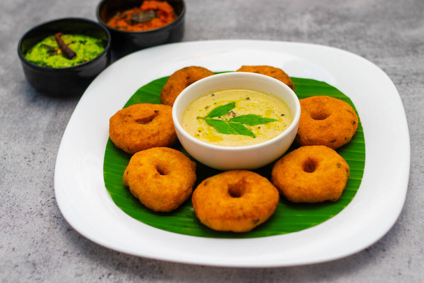 南インドの有名な食べ物"Medu Vada"の選択的な焦点 サンバラとココナッツチャットニー. - 写真・画像