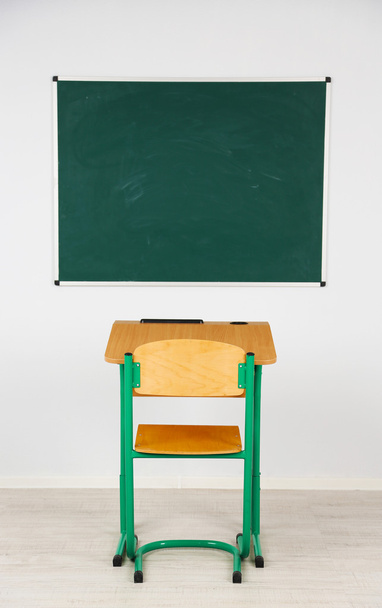 Доска и деревянный стол со стулом в классе
 - Фото, изображение
