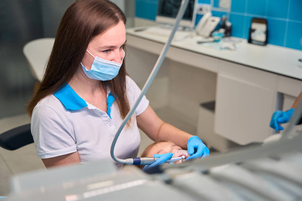 Dentista feminino remove placa de uma adolescente, equipamento odontológico moderno é usado - Foto, Imagem