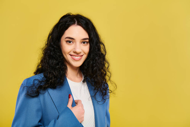 A brunette woman in a blue jacket and white shirt poses elegantly, expressing various emotions, against a vibrant yellow backdrop. - Photo, Image