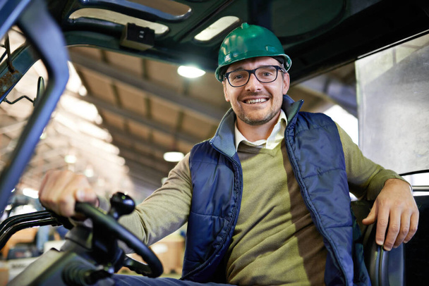 Man, portrait and forklift in warehouse driving for supply chain factory or logistics, import or delivery. Male person, face and hardhat for supplier manufacturing or courier, storage or distribution. - Photo, Image