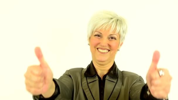 Mujer de mediana edad muestra pulgares en el acuerdo - fondo blanco - estudio
 - Metraje, vídeo