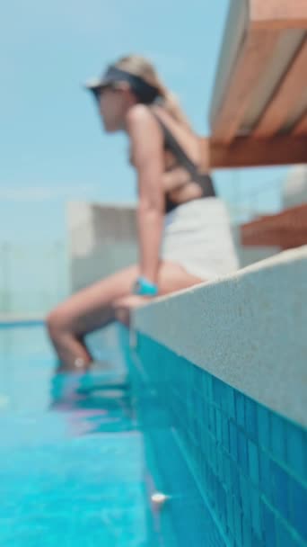 Молодая женщина расслабляется у бассейна, низкий раздел - Кадры, видео