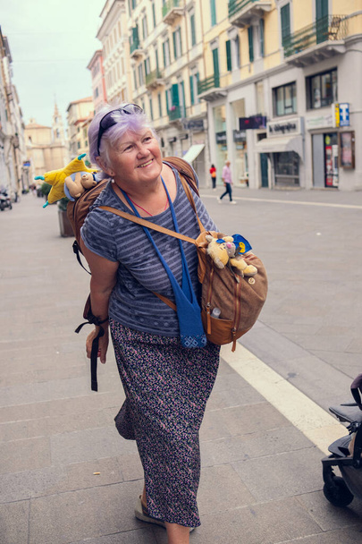高齢の女性がヨーロッパを旅する. バックパックを持った祖母がイタリアの街を歩き回ります. 高齢者は旅行を楽しんでいる. - 写真・画像