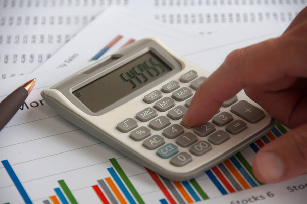 Calcolatrice a pressione manuale con carta per analisi finanziarie. Strategia aziendale e concetto di bilancio. - Foto, immagini