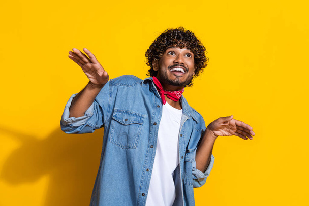 Photo portrait of nice young male hands wings look empty space dressed stylish denim outfit red scarf isolated on yellow color background. - Φωτογραφία, εικόνα