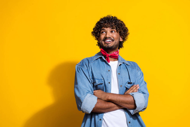 Photo portrait of nice young male folded hands look empty space dressed stylish denim outfit red scarf isolated on yellow color background. - 写真・画像