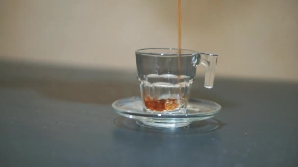 χύνοντας τσάι σε ένα λευκό γυάλινο κύπελλο σε ένα μαύρο τραπέζι - Πλάνα, βίντεο