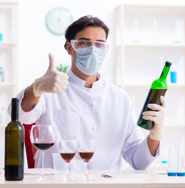 The male chemist examining wine samples at lab - Photo, Image
