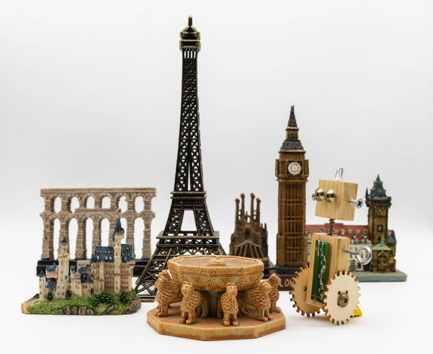 Деревянный ремесленный робот рядом с несколькими памятниками мира, такими как Эйфелева башня, Патио-де-лос-Леонес-де-ла-Альгамбра или Биг-Бен - Фото, изображение