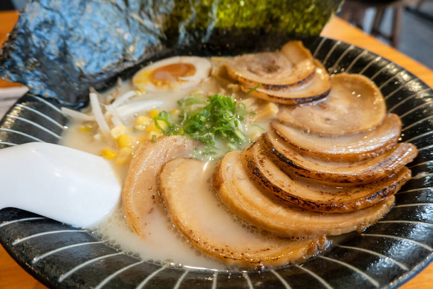 Tranches de ventre de porc au-dessus des ramen dans un bouillon riche, garni d'œufs et de légumes. - Photo, image
