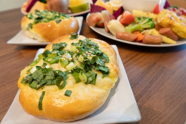 Frisch gebackenes Brot garniert mit grünen Zwiebeln und Sesam. - Foto, Bild