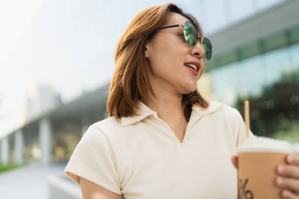 Podnikání asijské podnikatel chytrý žena pít kávu na kancelářské budovy pozadí žena ve městě - Fotografie, Obrázek