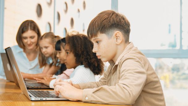 Çocuk BTMM Teknoloji sınıfında çok kültürlü bir arkadaşla bilgisayar oyunu oynuyor. Mühendislik kodları ve bulanık geçmişi olan programlama sistemi üzerine çok kültürlü bir öğrenci çalışması. Etkinlik. - Fotoğraf, Görsel