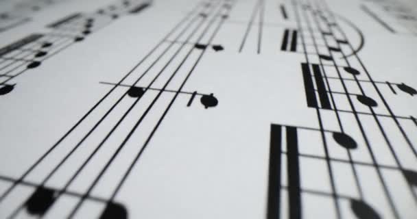 Μουσικό φύλλο στολισμένο με μελωδία φτιαγμένη από σύμβολα σημειώσεων. Αρμονική σύνθεση έτοιμη για συναυλία σε λευκό χαρτί - Πλάνα, βίντεο