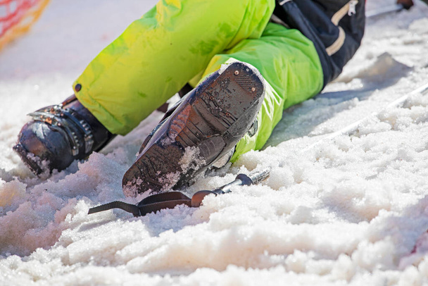 лижник одягає гірськолижні черевики на сніжному схилі. активний відпочинок з сім'єю - Фото, зображення
