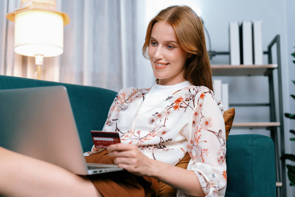 Nuori onnellinen nainen ostaa tuotteen online-ostoksia kotona tilatessaan kohteita Internetistä luottokortilla online-maksujärjestelmä suojattu äärimmäisen kyberturvallisuus verkkokaupasta alustan - Valokuva, kuva