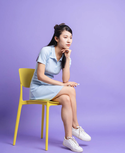 Фото молодой азиатской девушки на фиолетовом фоне - Фото, изображение