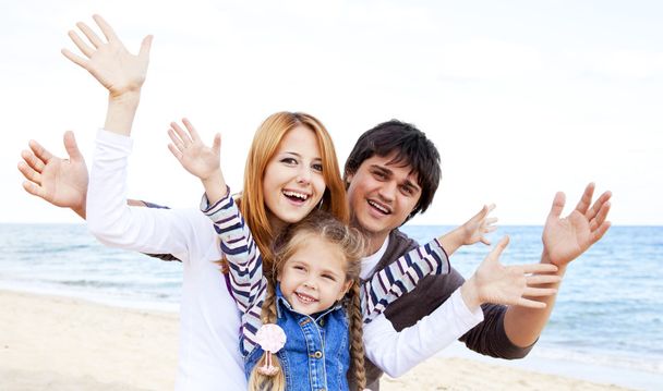 Młoda rodzina na plaży jesienią - Zdjęcie, obraz