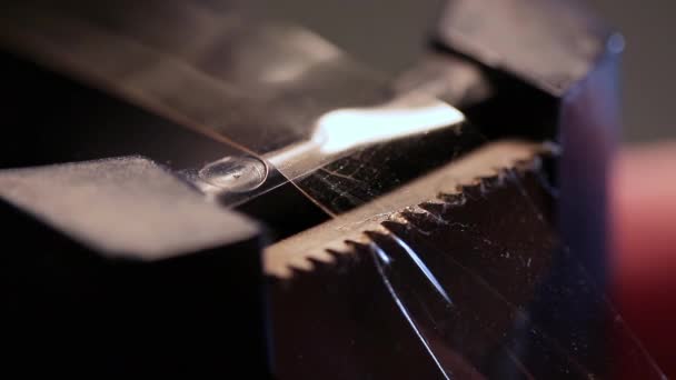 Tirare scotch nastro in nastro dispenser in macro shot - Filmati, video