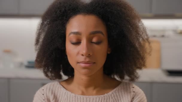 Közelkép etnikai lány arc Afrikai amerikai nő az otthoni konyhában komoly látszó kamera női fejlövés portré fiatal hölgy göndör frizura egészséges bőr természetes szépség egészségügyi biztosítás - Felvétel, videó