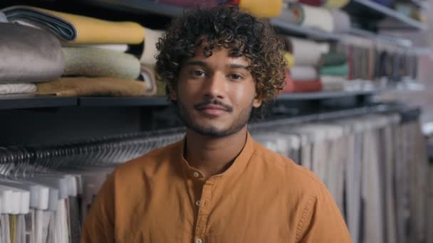 Arabský indický etnický muž zákazník prodavač módní návrhář krejčí stylista v textilním obchodě textilní obchod šťastný muž majitel malé firmy atelier krejčovství oblečení tkaniny střílení chlap s úsměvem na kameru - Záběry, video
