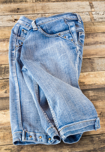 Блакитні джинси на старій дерев'яній поверхні
 - Фото, зображення