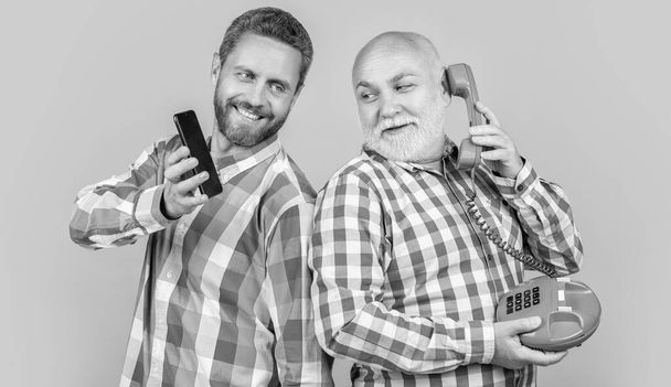 happy men with vs technology isolated on yellow. happy men with vs technology in studio. men with vs technology on background. photo of men with vs technology phone and telephone. - Φωτογραφία, εικόνα