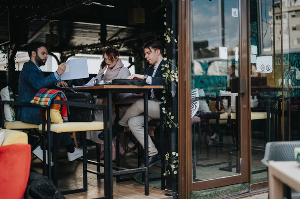 Молодые предприниматели, участвующие в продуктивной деловой встрече в современном кафе, обсуждают стратегии роста компании. - Фото, изображение