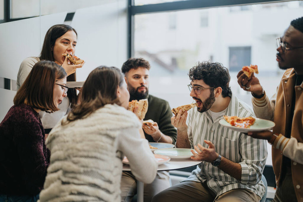 Monirotuinen liike-elämän joukkue pitää virkistävän tauon ja nauttii pizzasta yhdessä. - Valokuva, kuva