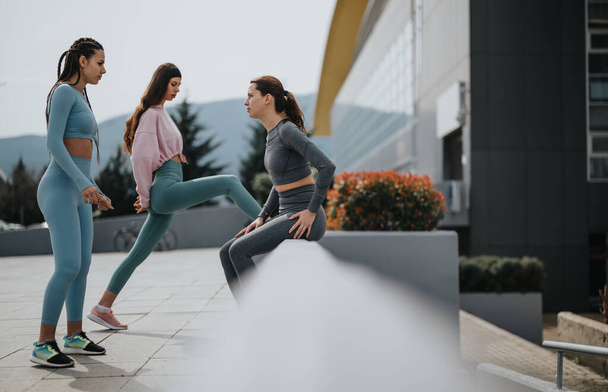 Grupo de amigos haciendo ejercicio juntos al aire libre, mostrando fitness y estilo de vida urbano. - Foto, imagen