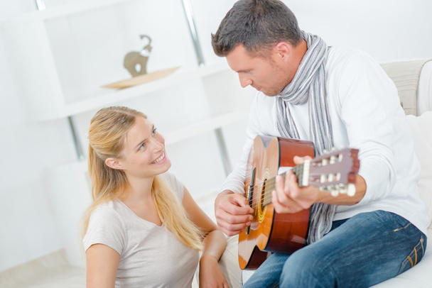 Playing guitar for his wife - Фото, изображение
