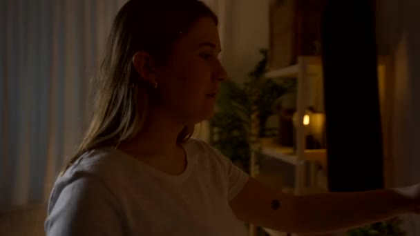 Молода жінка вмикає свічку вночі - Кадри, відео