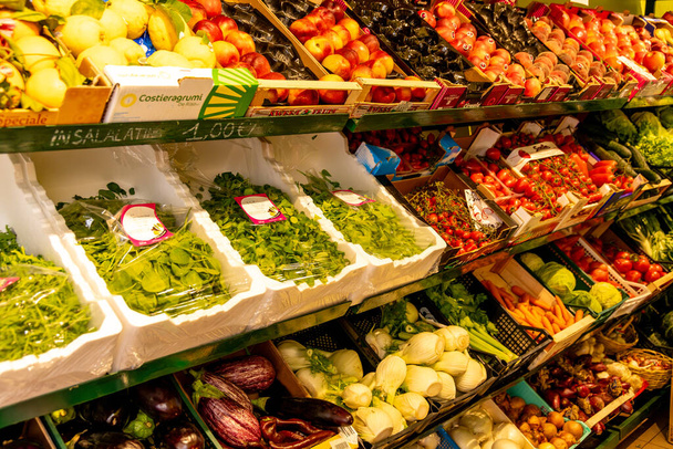 Treviso, Venetien - Italien - 06-08-2021: Sortiertes frisches Gemüse und Obst sauber und ansprechend in den Regalen eines italienischen Marktes angeordnet - Foto, Bild