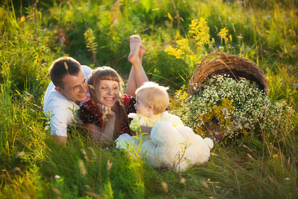 夏の草原で屋外楽しんで幸せな家族 - 写真・画像