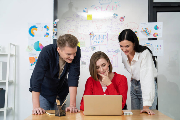 Professionele business team samen te werken door het gebruik van laptop in start-up project op vergadering in de voorkant van glazen bord met mindmap, terwijl collega brainstorm en bespreken over de strategie. Onbevlekt. - Foto, afbeelding