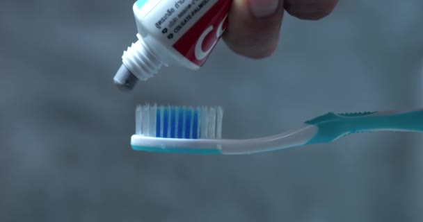 Hand drückt kleine Menge Zahnpasta Zahnbürste, grundlegender Schritt zur Erhaltung der Mundgesundheit. Action preps Pinseleinsatz, bedeutet tägliches Engagement Zahngesundheit. Routinen, unterstreichen Bedeutung Gesundheit - Filmmaterial, Video