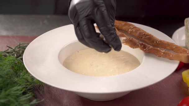 Chef bereitet köstliche Frischkäsesuppe bestreut mit geriebenem Parmesan und serviert. Nahaufnahme - Filmmaterial, Video